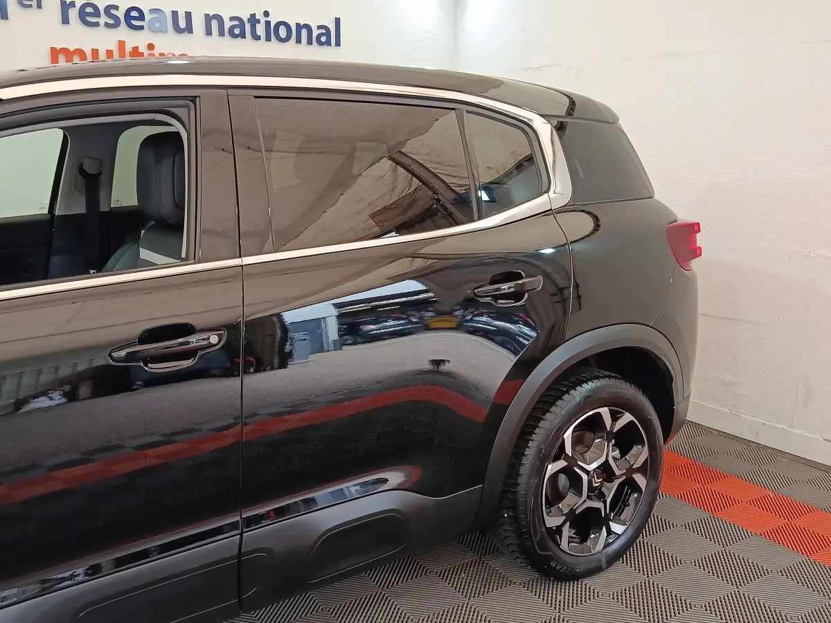 Vue latérale côté droit du Citroën C5 Aircross noir 2024, mettant en valeur la roue arrière et les vitres teintées.