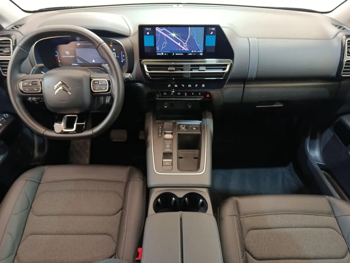 Vue intérieure avant du Citroën C5 Aircross noir 2024, tableau de bord moderne avec écran tactile central et volant cuir.