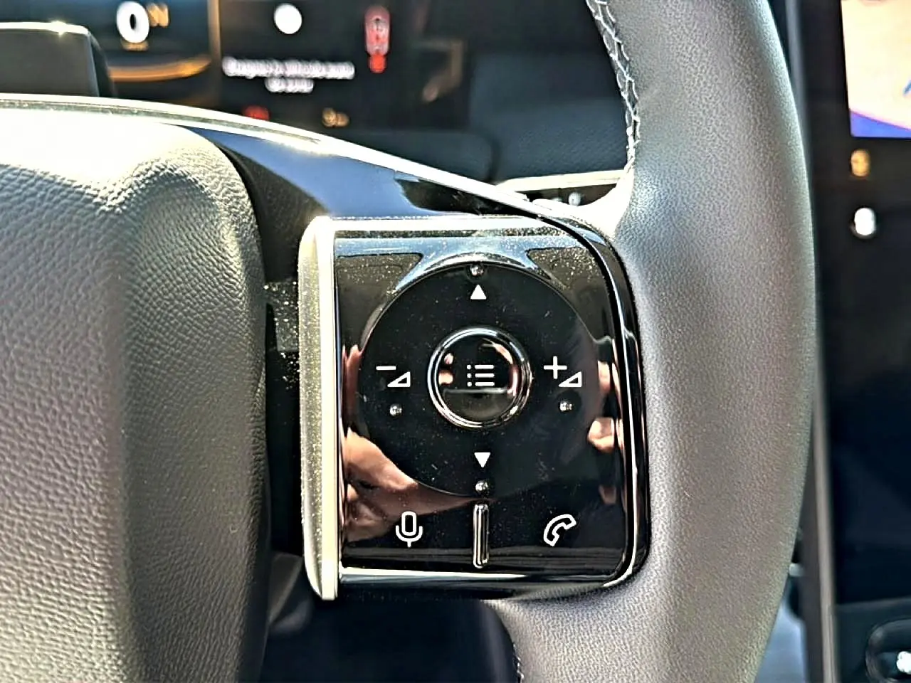 Gros plan sur les commandes gauche du volant noir du Citroën C5 Aircross hybride blanc/noir de 2026.