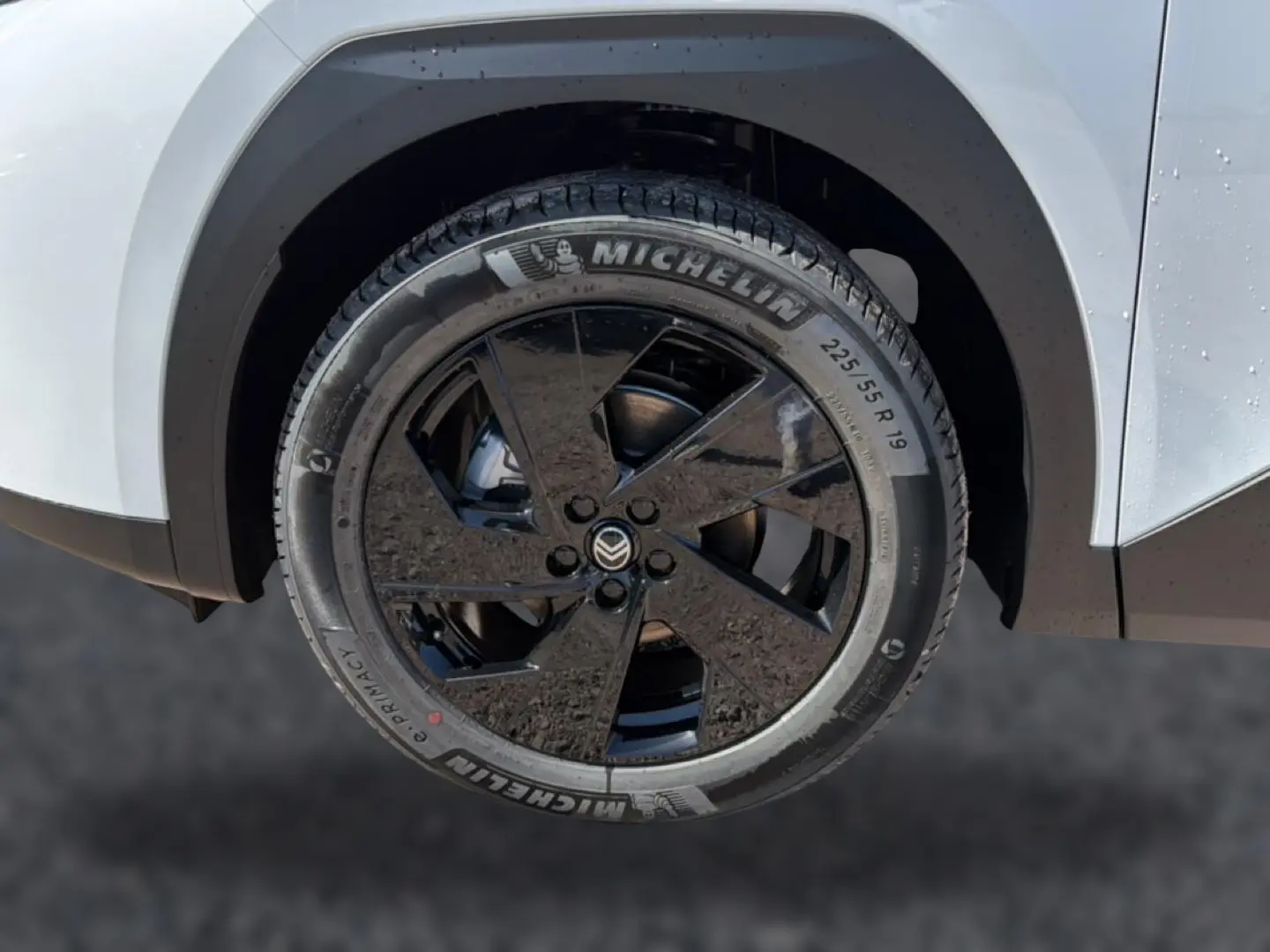 Gros plan sur la roue avant droite du Citroën C5 Aircross blanc avec jante alliage noire 19 pouces et pneu Michelin.