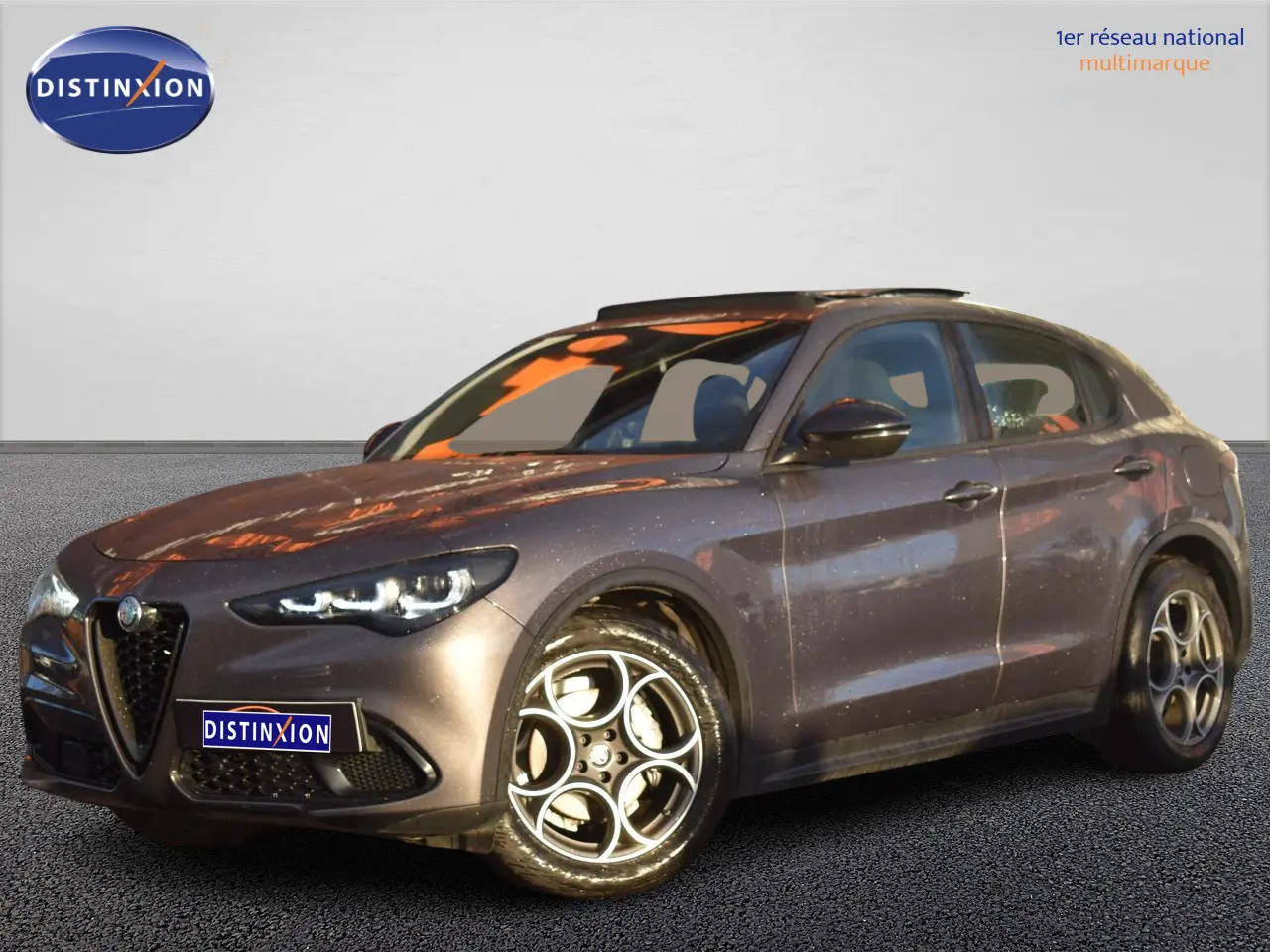 Alfa Romeo Stelvio 2024 gris Vesuvio en 3/4 avant droit avec toit panoramique et jantes alliage 19 pouces.