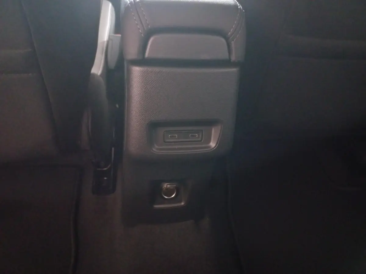 Vue rapprochée de la console arrière noire de la Citroën C3 hybride 2025 avec ports USB-C et prise 12V.