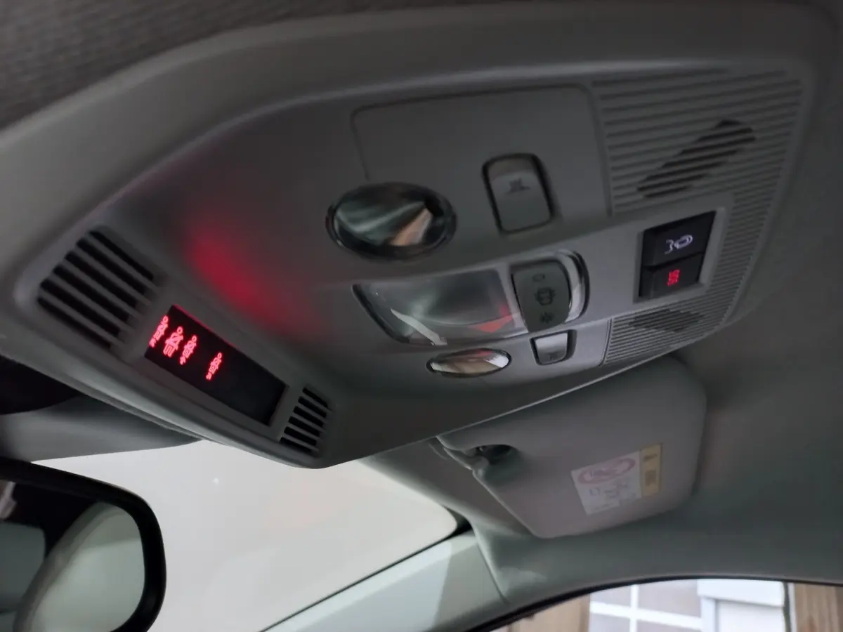 Vue intérieure en plongée du plafonnier gris avec commandes d’éclairage et affichage rouge sur une Citroën C3 hybride 2025.
