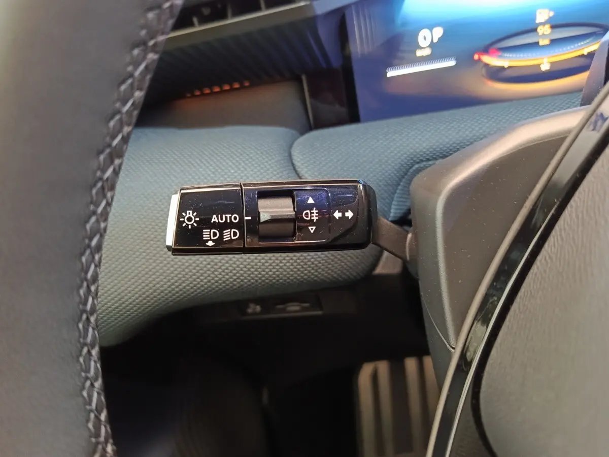 Gros plan sur la commande des feux et clignotants côté gauche du tableau de bord d’une Citroën C5 hybride verte.