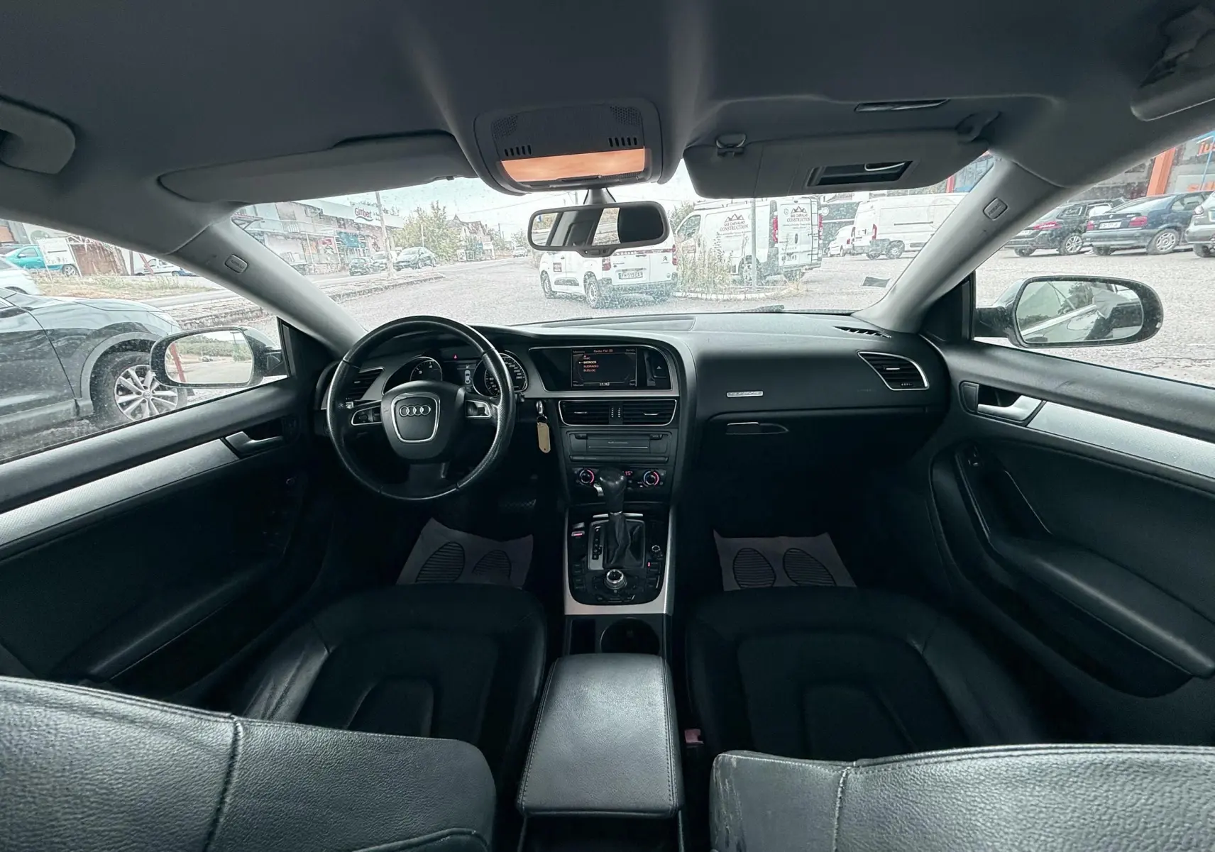 Vue intérieure avant de l'Audi A5 Sportback 2009 avec tableau de bord et sièges en cuir noir.