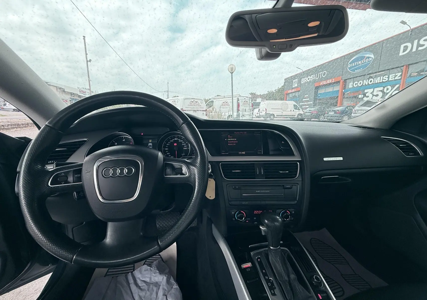 Vue intérieure frontale de l'Audi A5 Sportback 2009, volant cuir noir et console centrale avec boîte auto.