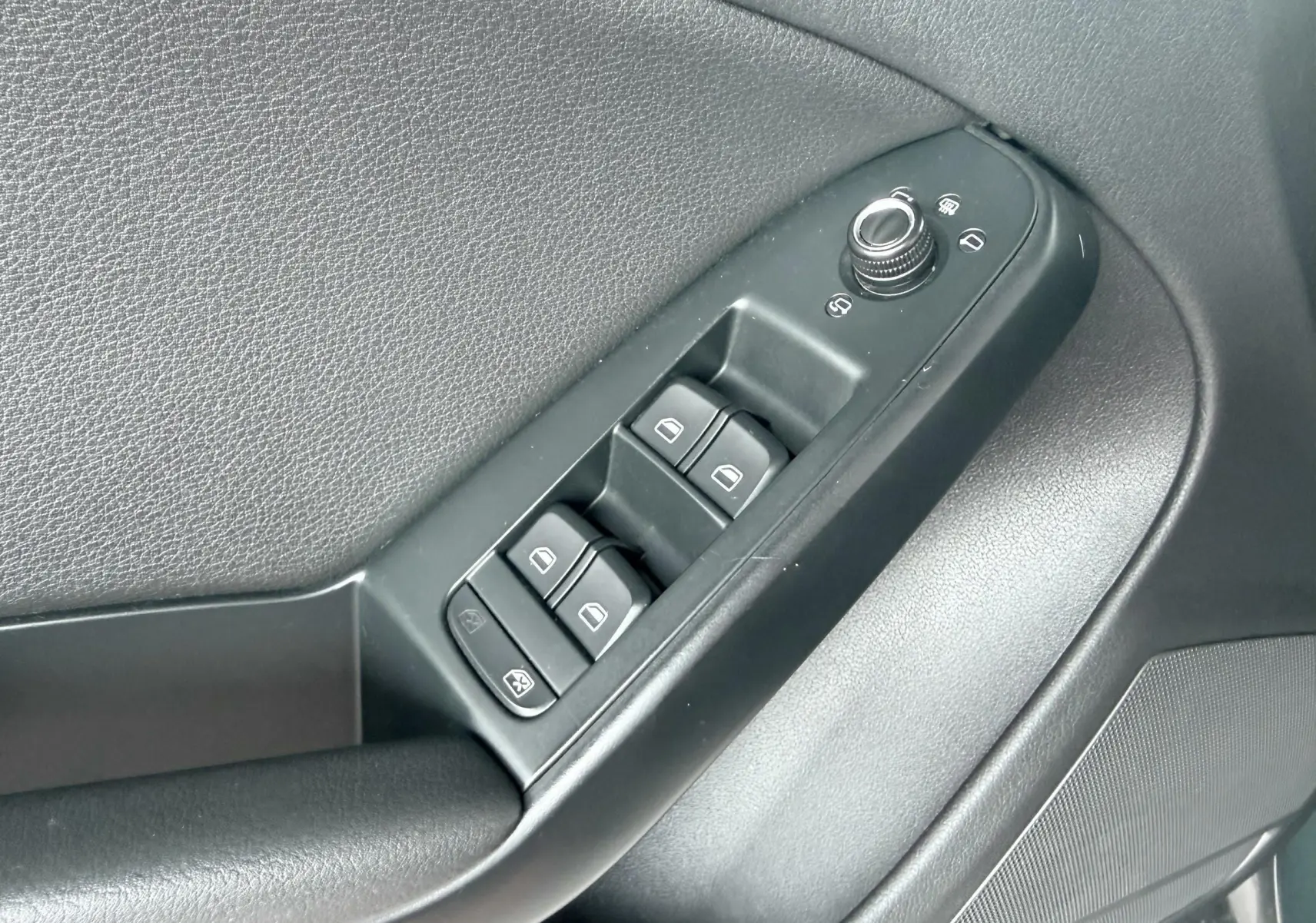 Gros plan sur les commandes des vitres électriques et rétroviseurs côté conducteur d'une Audi A5 Sportback 2009.
