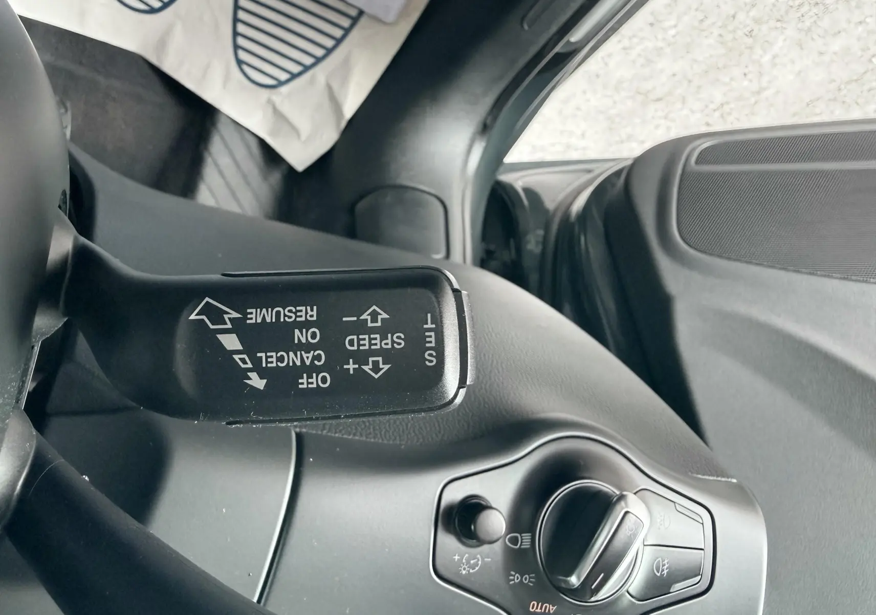 Détail du commodo de régulateur de vitesse et commande des phares côté gauche dans l’habitacle gris d’une Audi A5 Sportback.