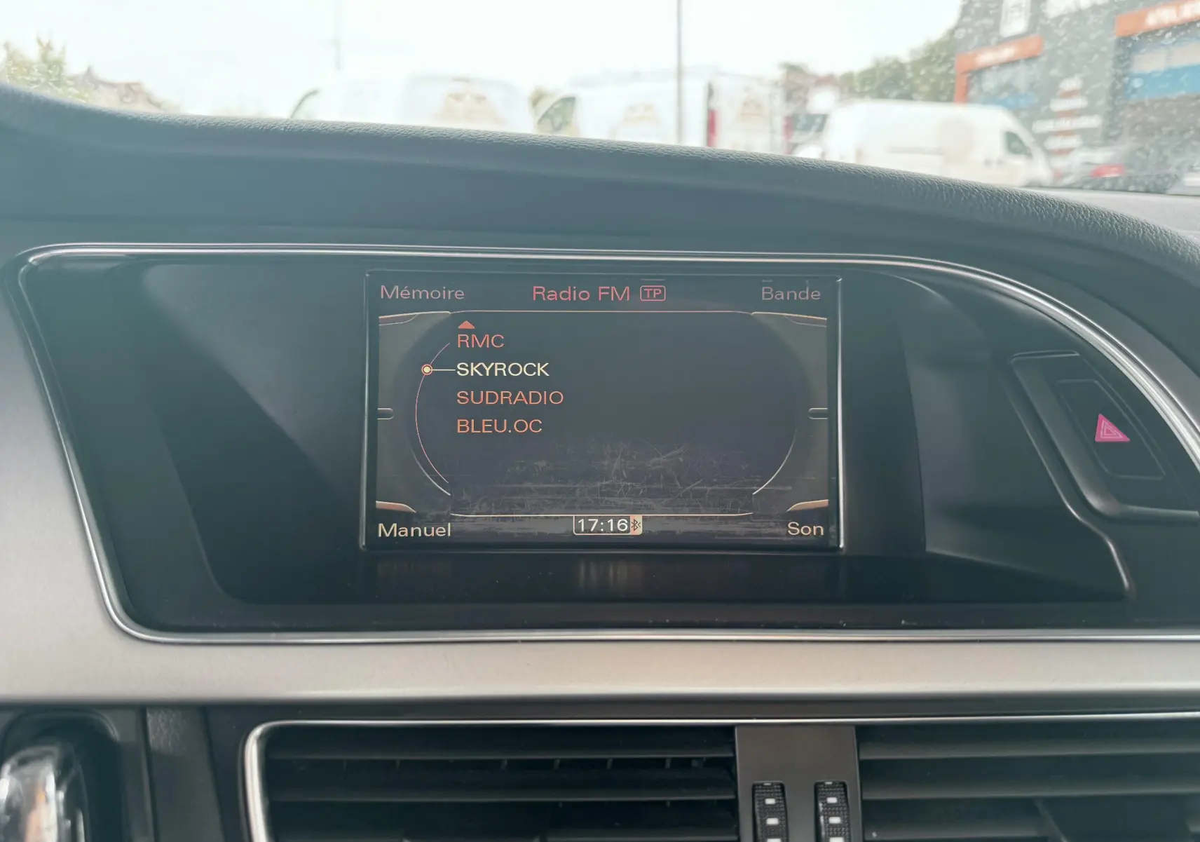 Écran central de l'Audi A5 Sportback 2009 affichant les stations radio FM, entouré de la console noire et grise.
