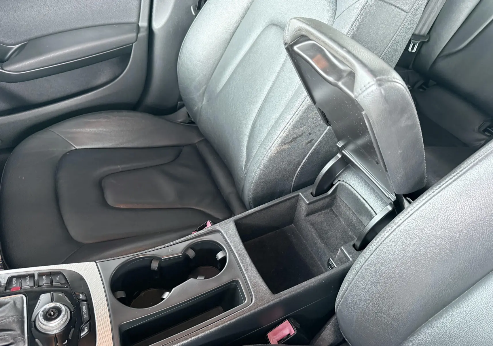 Vue intérieure rapprochée du siège conducteur noir et de l'accoudoir central ouvert de l'Audi A5 Sportback 2009.