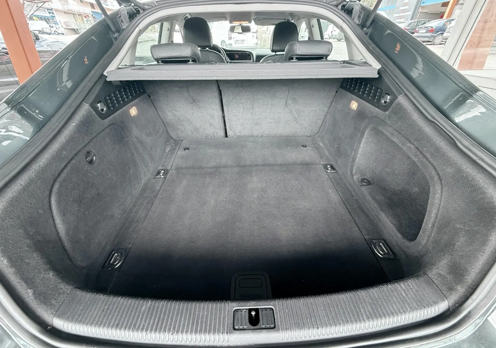 Vue arrière du coffre spacieux et propre de l'Audi A5 Sportback gris dauphin, avec banquette arrière visible.