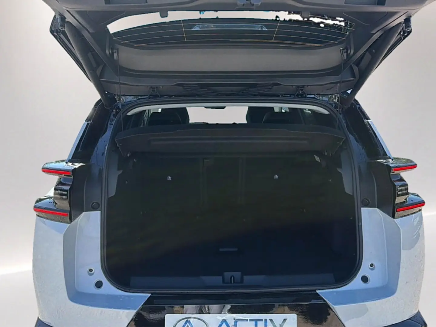 Vue arrière ouverte du Citroën C5 Aircross 2026 blanc et noir, mettant en valeur le coffre spacieux et le toit bi-ton.