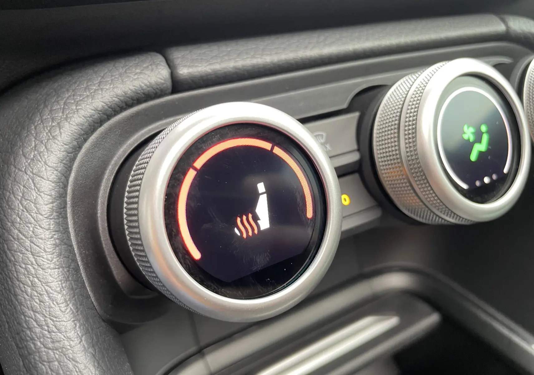 Gros plan sur les commandes circulaires du chauffage des sièges et de la ventilation dans le Skoda Kodiaq noir métal 2024.