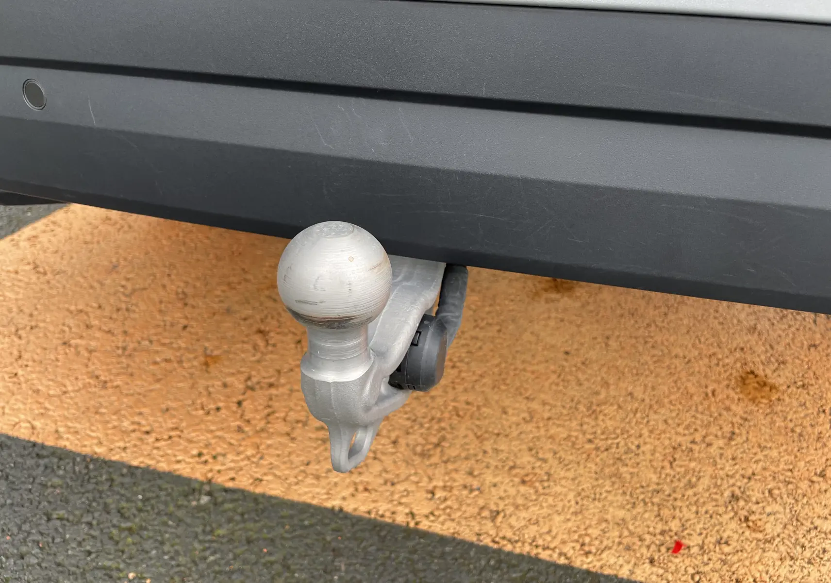 Gros plan sur l'attelage arrière en métal d'un Skoda Kodiaq noir métal 2024, soulignant sa robustesse et fonctionnalité.