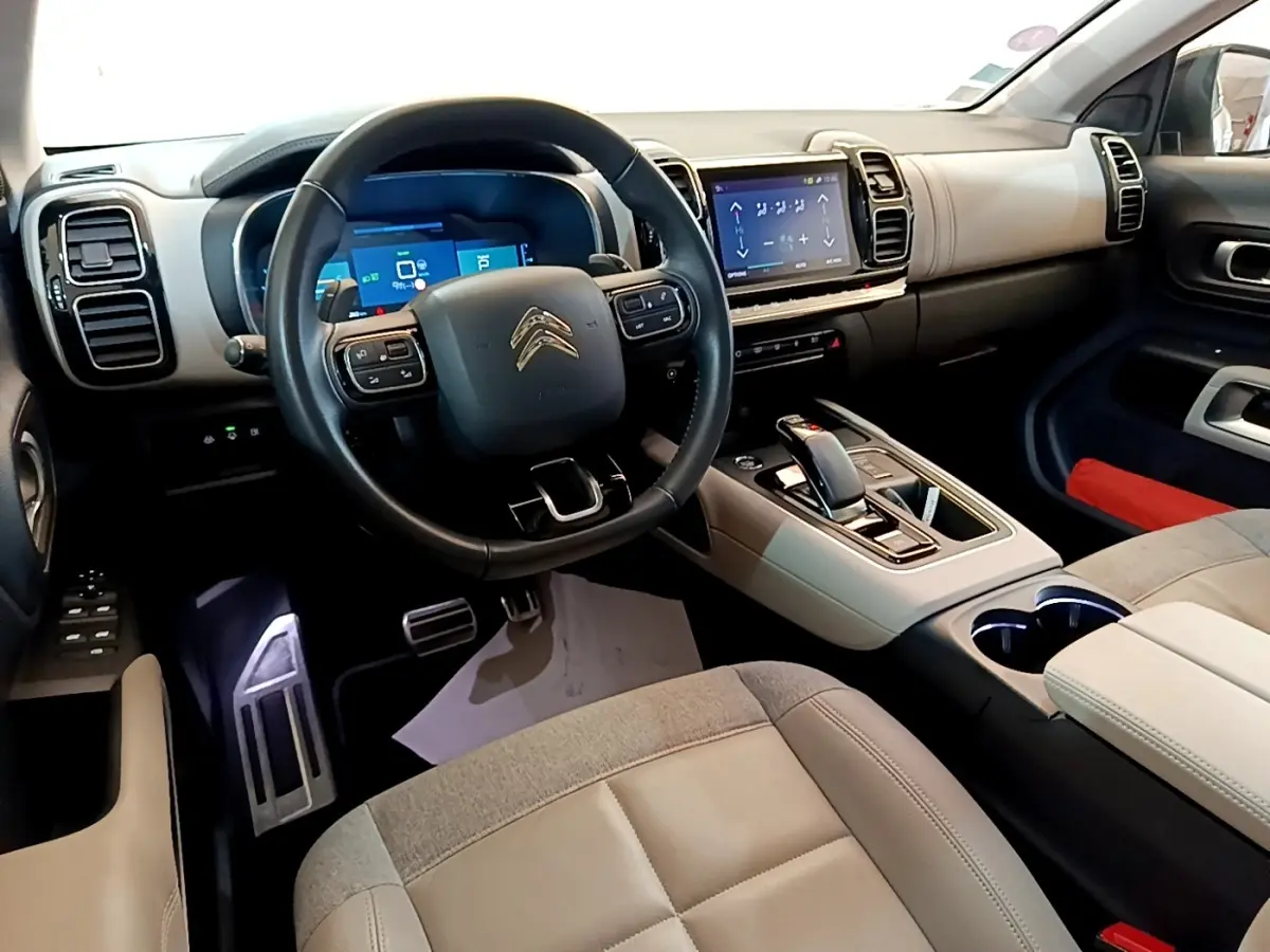Vue intérieure avant droite du Citroën C5 Aircross Hybrid 225 avec volant cuir, écran tactile et console centrale beige et noire.