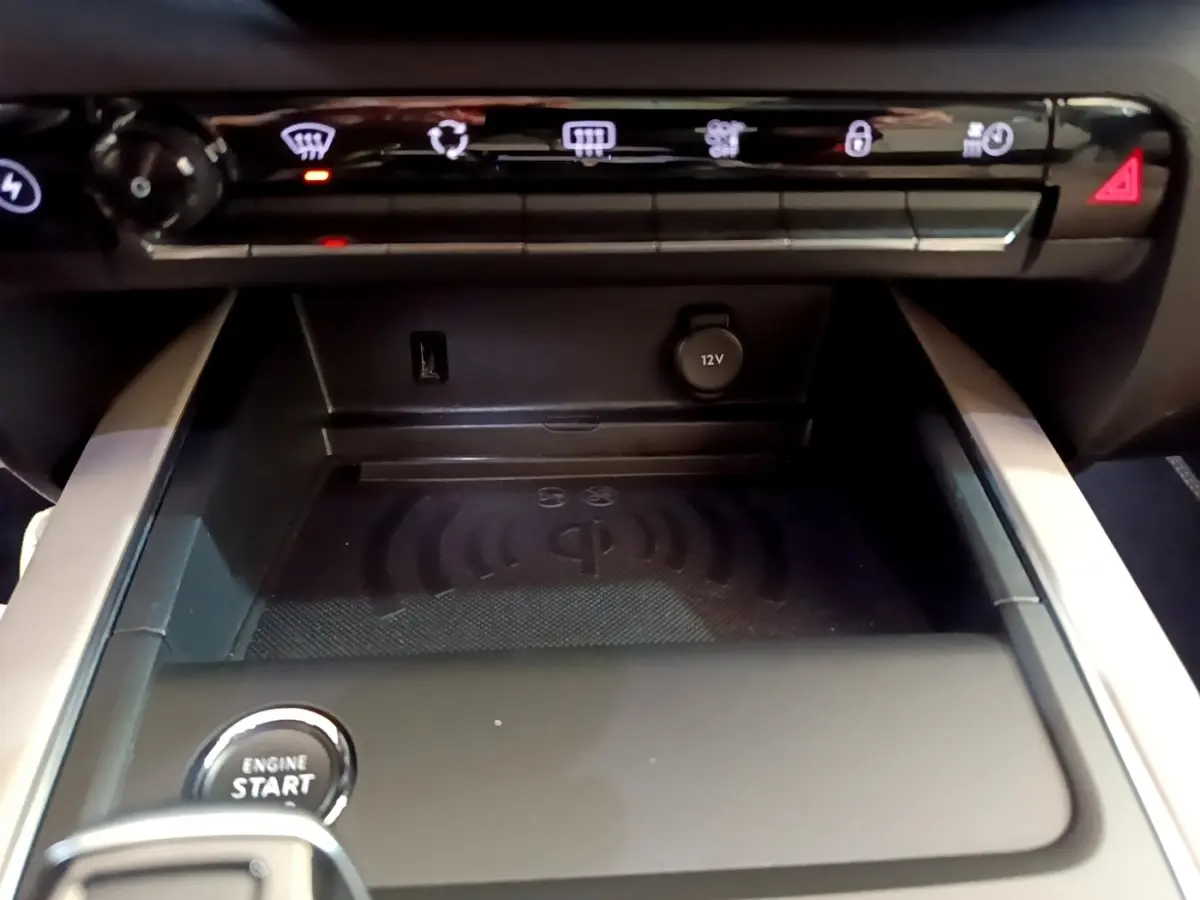 Gros plan sur la console centrale noire du Citroën C5 Aircross Hybrid avec bouton démarrage et prise 12V visible.