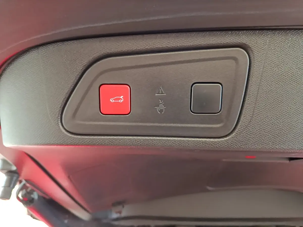 Gros plan sur les boutons de commande du coffre, intérieur noir du Citroën C5 Aircross Hybrid blanc.