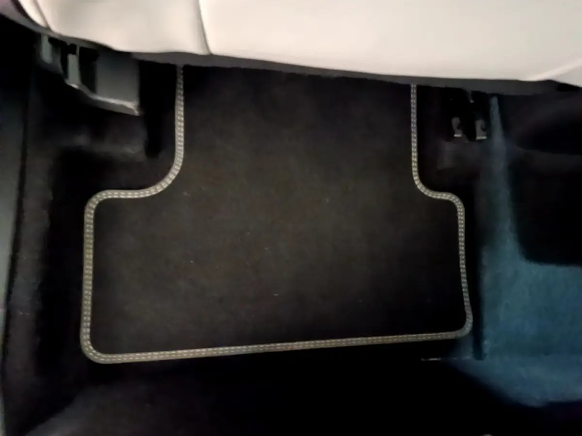 Tapis de sol noir avec surpiqûres blanches sous le siège avant d'une Citroën C5 Aircross Hybrid 225 ë-EAT8 Shine Pack.