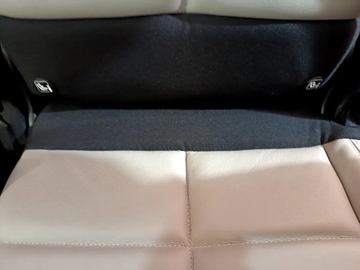 Gros plan sur la banquette arrière en cuir beige du Citroën C5 Aircross Hybrid 225 ë-EAT8 Shine Pack, avec fixation Isofix visible.