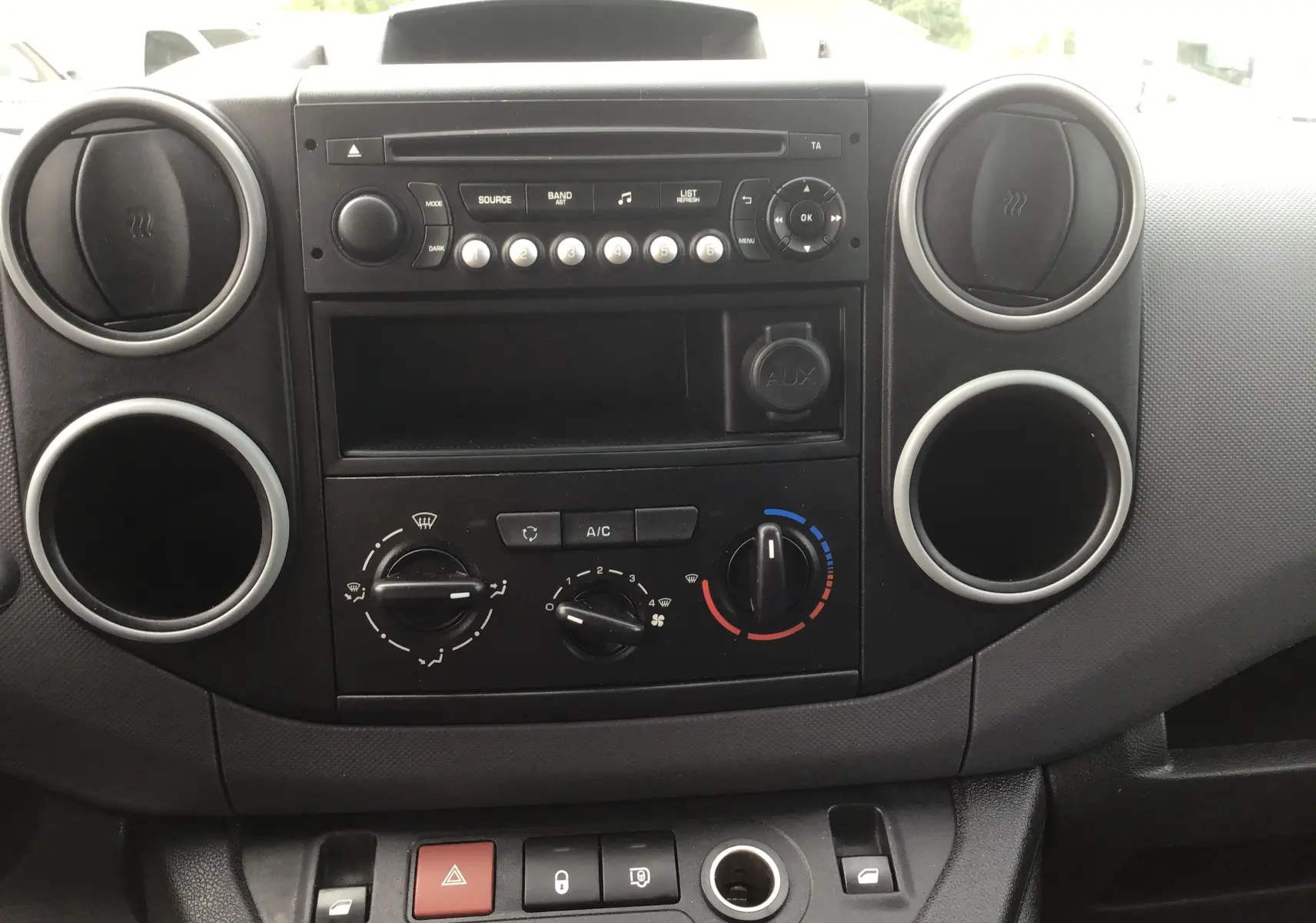 Vue rapprochée du tableau de bord noir du Citroën Berlingo XL 2018, avec commandes de climatisation et radio intégrée.