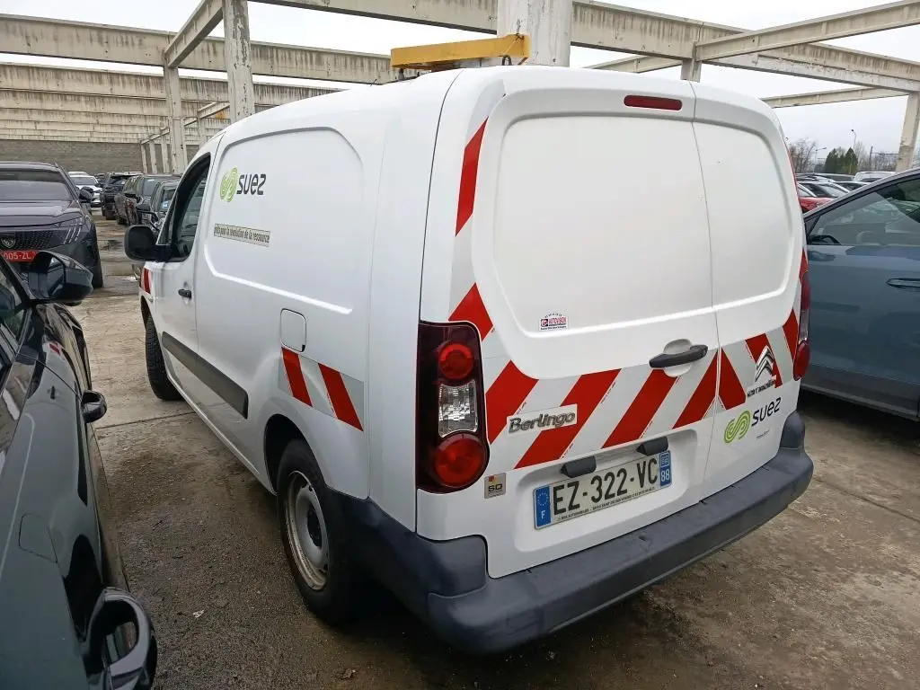 Vue 3/4 arrière droite d'un Citroën Berlingo blanc utilitaire avec bandes rouges réfléchissantes et logo Suez sur porte arrière.