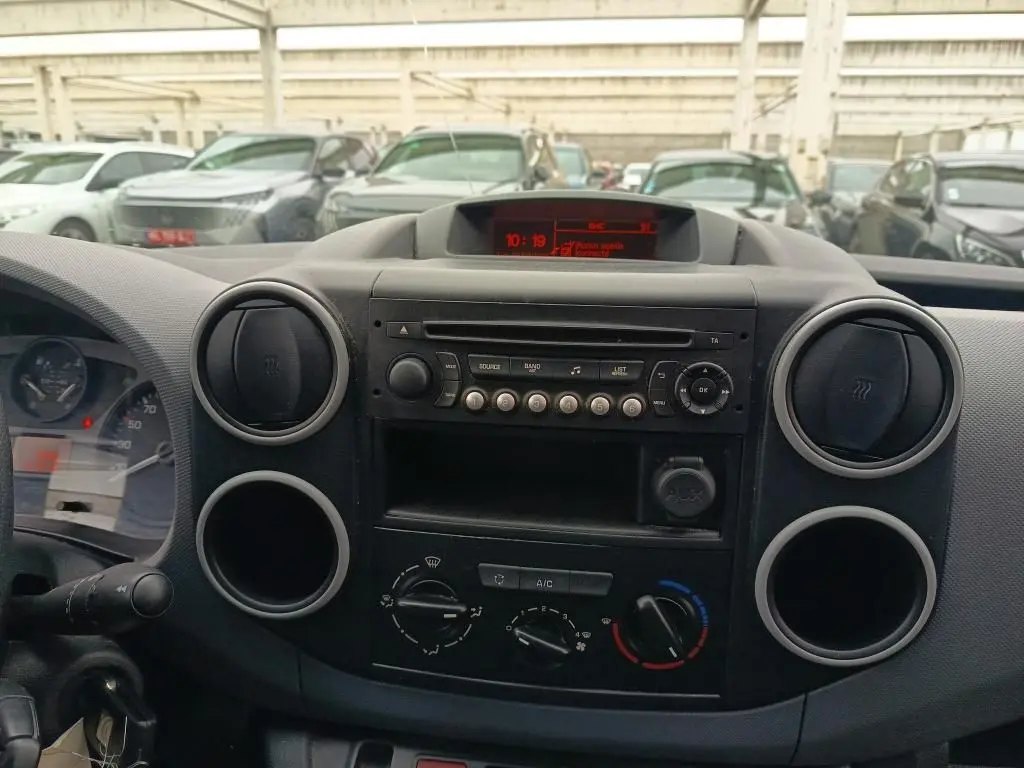 Tableau de bord intérieur du Citroën Berlingo XL blanc, vue frontale centrée sur la console radio et climatisation.