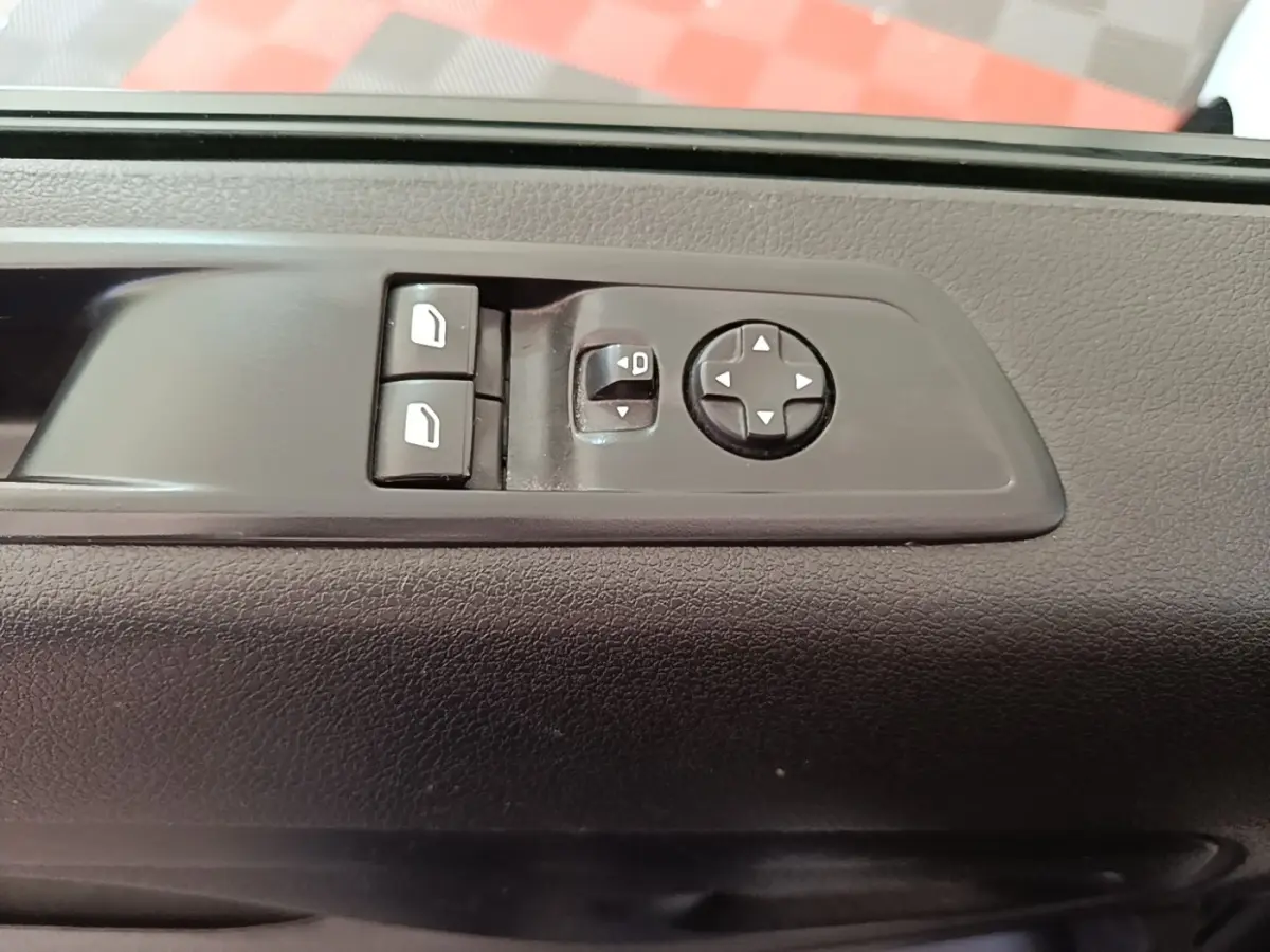 Gros plan sur les commandes de réglage des rétroviseurs électriques sur la porte intérieure noire du Peugeot Expert Fourgon blanc.