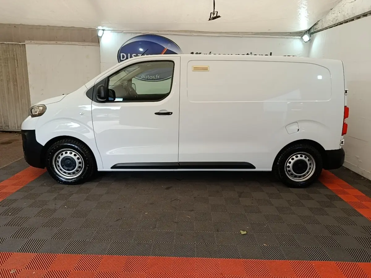 Vue de profil côté gauche d’un Peugeot Expert Fourgon blanc, avec porte latérale coulissante et jantes acier.