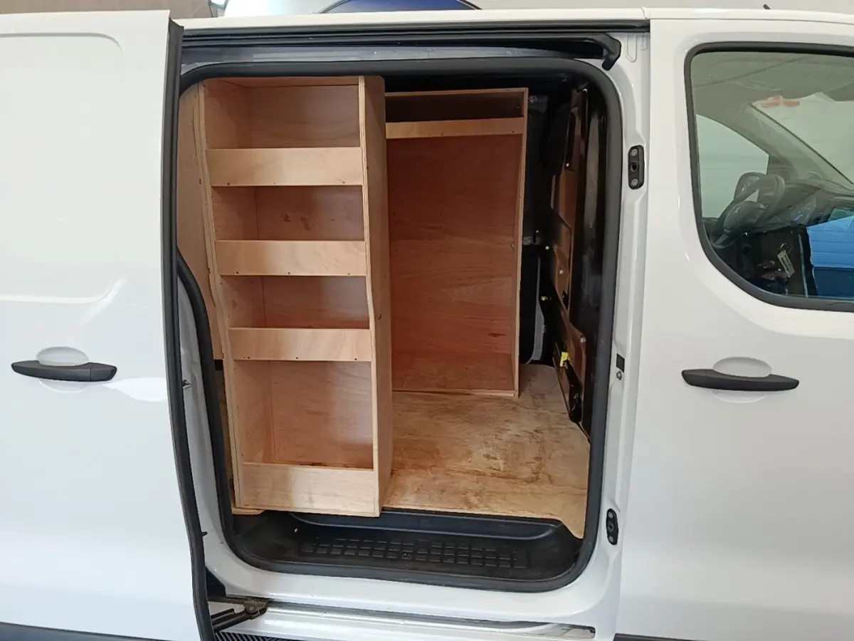 Vue latérale droite d’un Peugeot Expert Fourgon blanc 2023 avec porte coulissante ouverte et aménagements bois dans la zone de chargement.