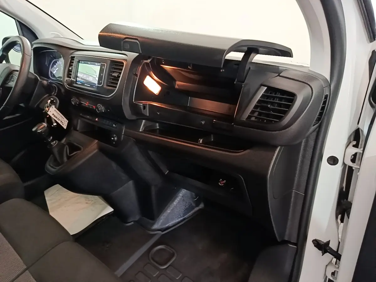 Intérieur du Peugeot Expert Fourgon blanc 2023, vue côté passager avec boîte à gants ouverte et écran tactile allumé.