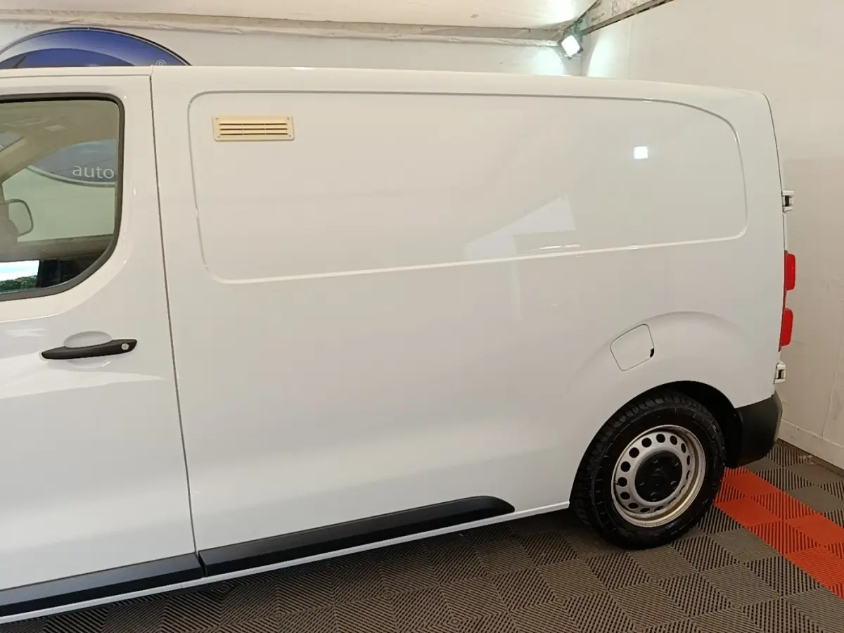 Vue latérale droite d’un Peugeot Expert Fourgon blanc, avec porte latérale pleine et jante acier simple.