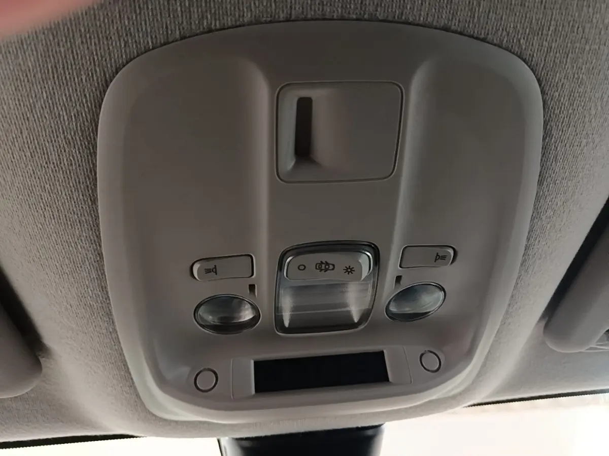 Plafonnier intérieur gris clair du Peugeot Expert Fourgon blanc, avec commandes d’éclairage et capteurs intégrés.