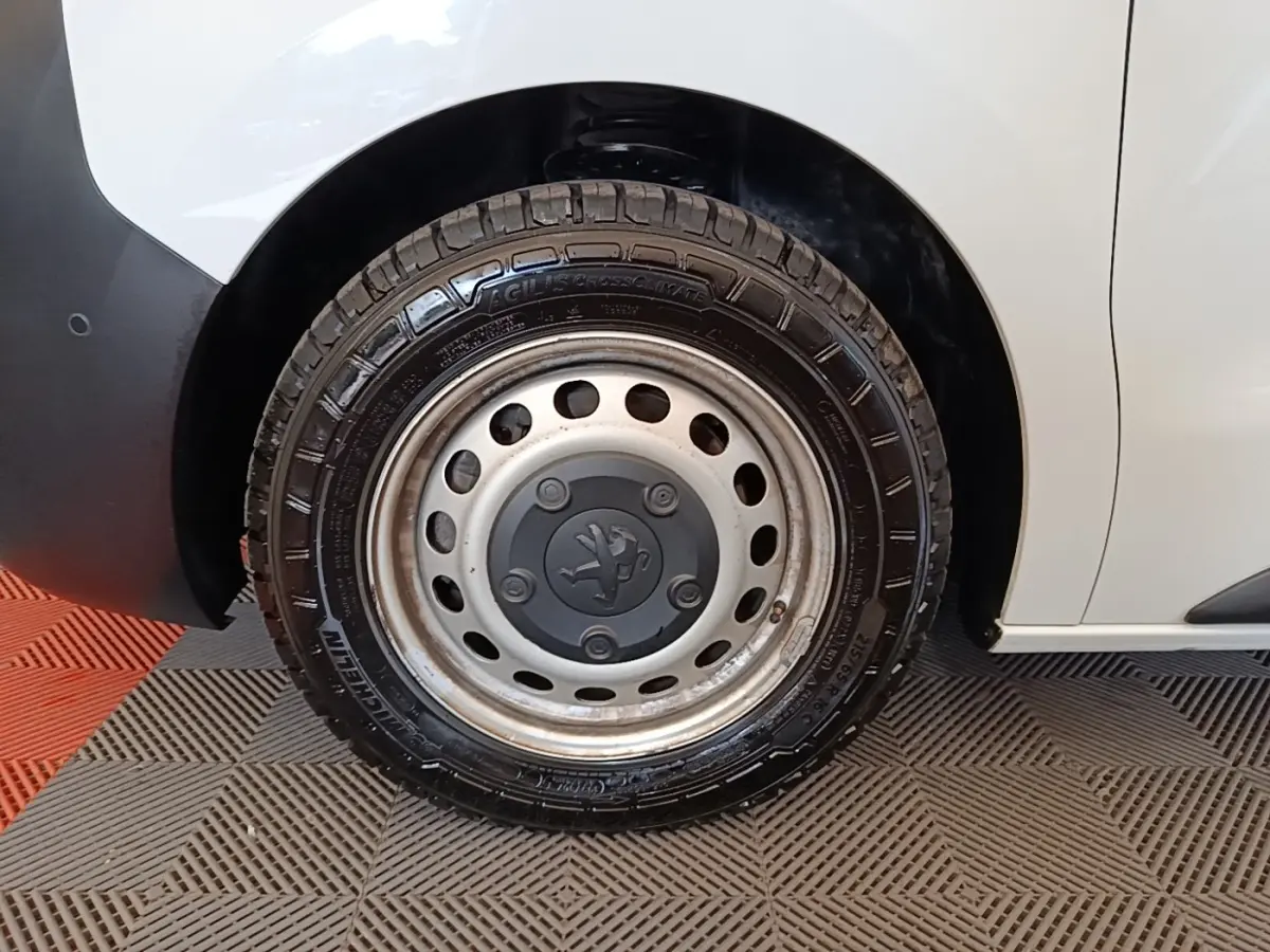 Gros plan sur la roue avant droite du Peugeot Expert Fourgon blanc, avec jante acier et logo Peugeot central.