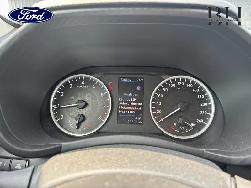 Tableau de bord du Nissan Juke 2023 avec compte-tours, compteur de vitesse et écran multifonction affichant les réglages.