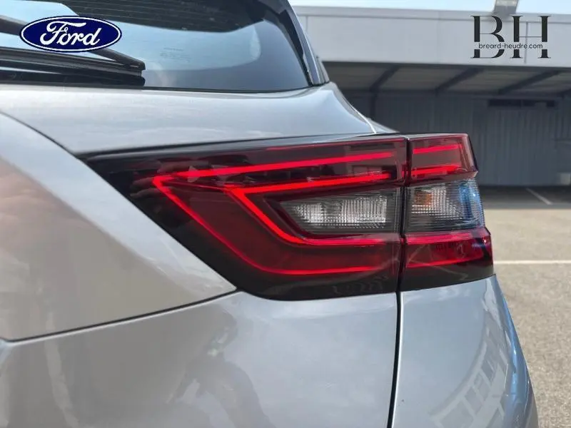 Gros plan sur le feu arrière droit rouge et blanc d'un Nissan Juke gris perle métallisé, vue arrière détaillée.