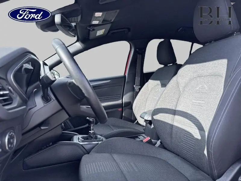 Intérieur avant de la Ford Focus 1.0 EcoBoost 2020, vue côté conducteur, sièges tissu noir et volant cuir multifonction.