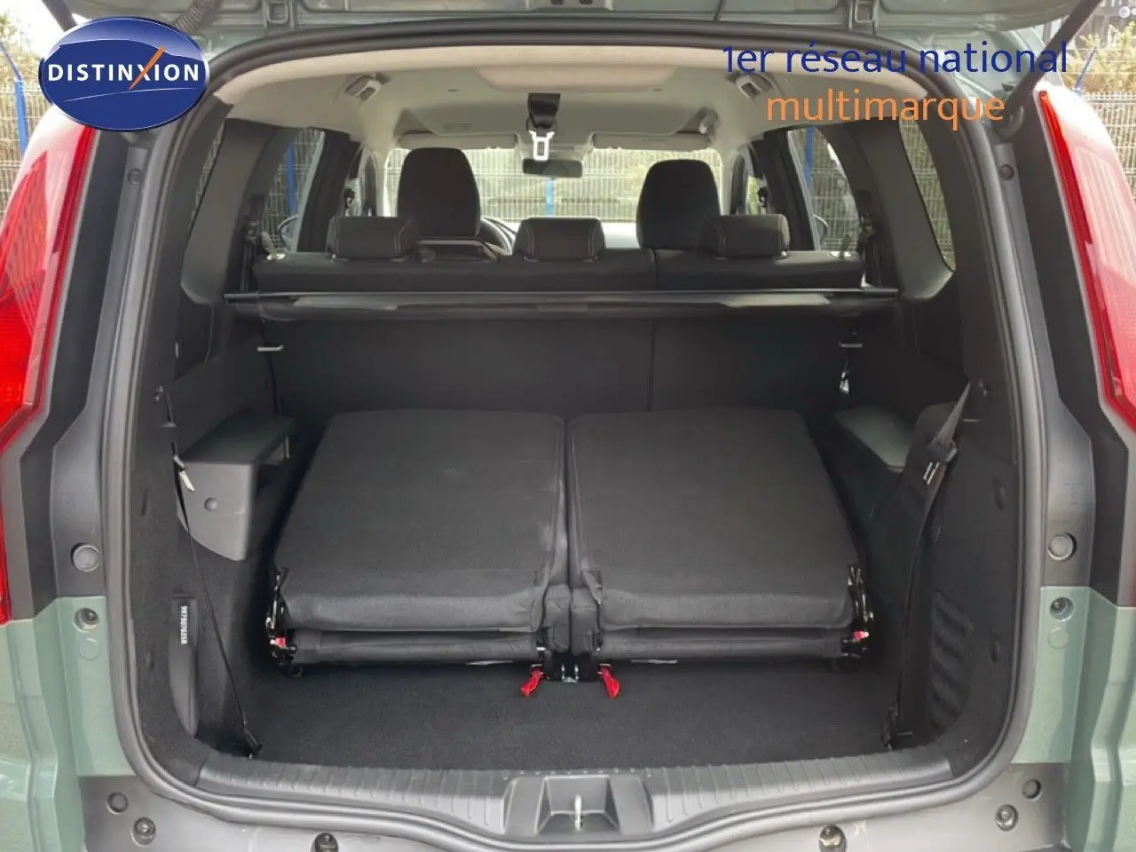 Vue arrière du Dacia Jogger gris schiste métal avec hayon ouvert et sièges arrière rabattus dans le coffre.