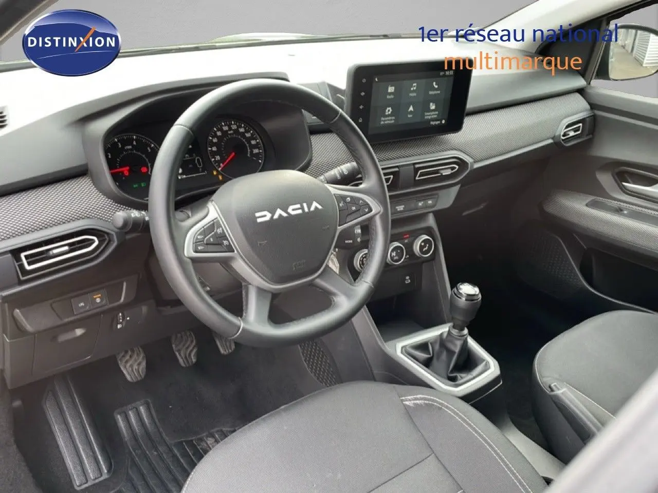 Vue intérieure côté conducteur du Dacia Jogger 1.0 ECO-G 100CH Expression 2025, tableau de bord noir avec volant cuir et boîte manuelle.