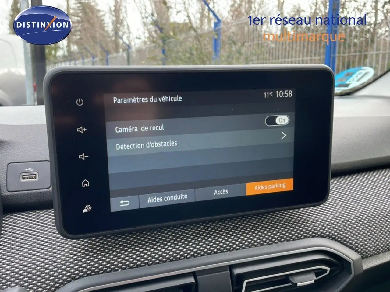 Vue intérieure centrée sur l'écran tactile du tableau de bord du Dacia Jogger gris schiste métal, affichant les paramètres de caméra de recul.