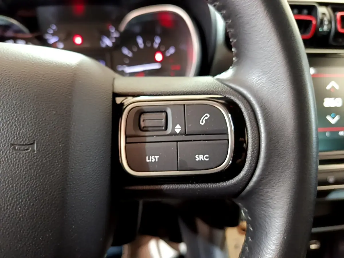 Gros plan sur les commandes gauche du volant cuir du Citroën C3 Aircross 2020, boutons de téléphone et liste visibles.