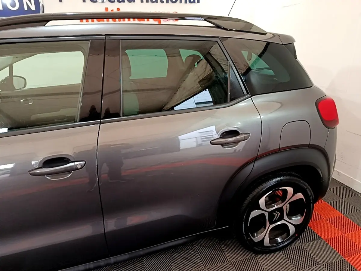 Vue latérale droite d'un Citroën C3 Aircross gris foncé avec jantes alliage et toit noir contrasté.