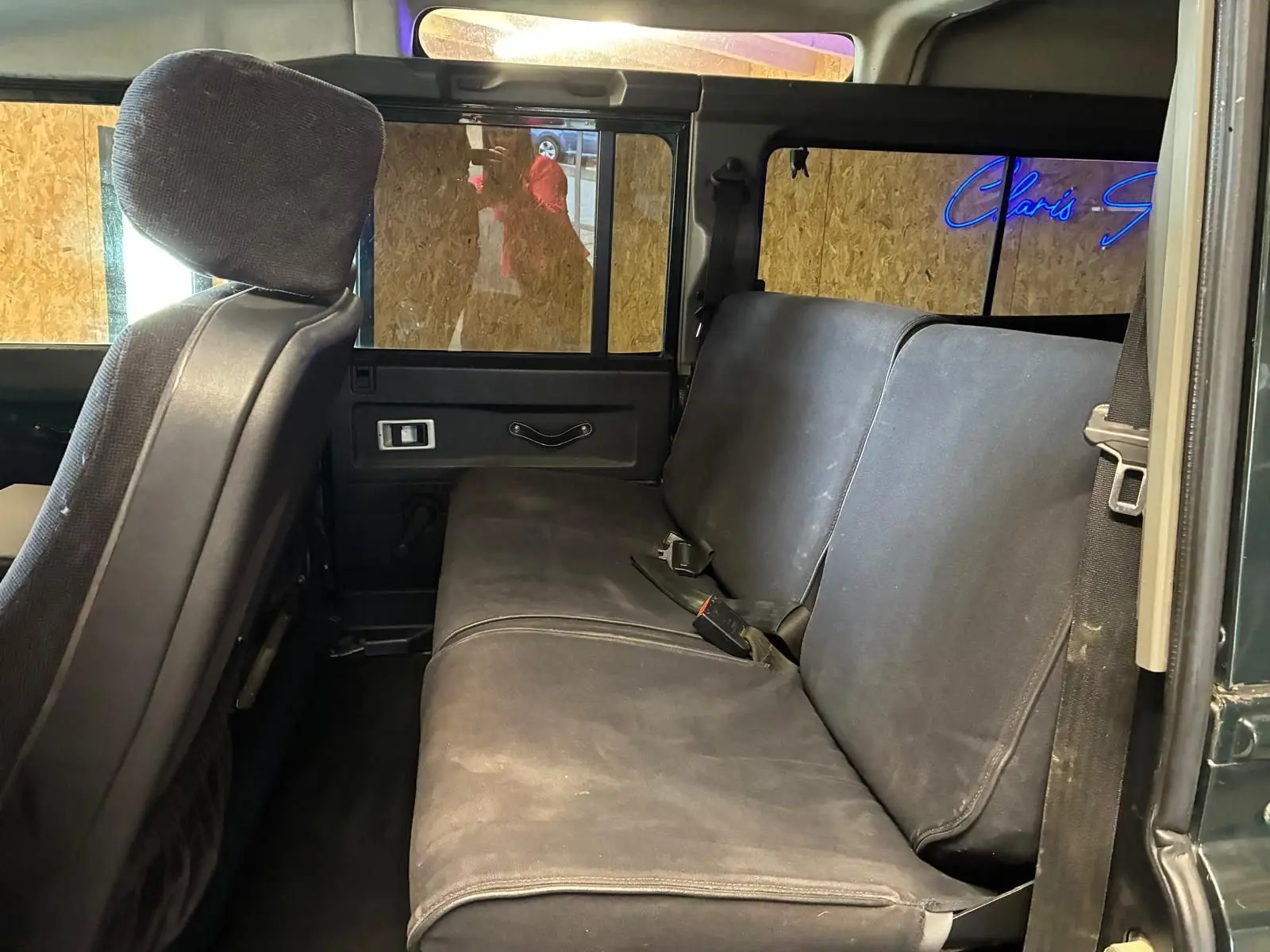 Vue intérieure côté droit du Land Rover Defender 110 2.5 TD 122 4x4 2005, sièges arrière en tissu noir.
