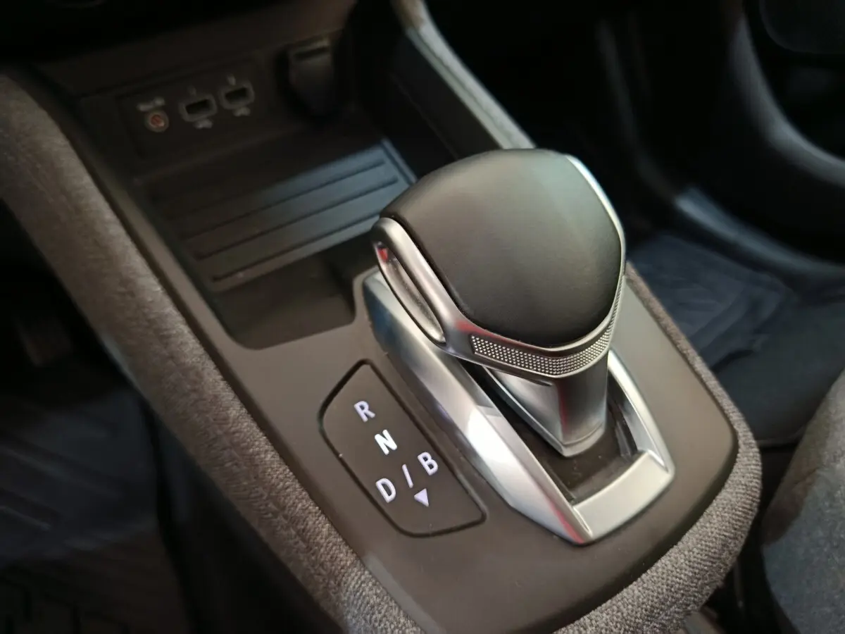Gros plan sur la commande de boîte automatique noire et argentée de la Renault ZOE blanche, version électrique 2023.