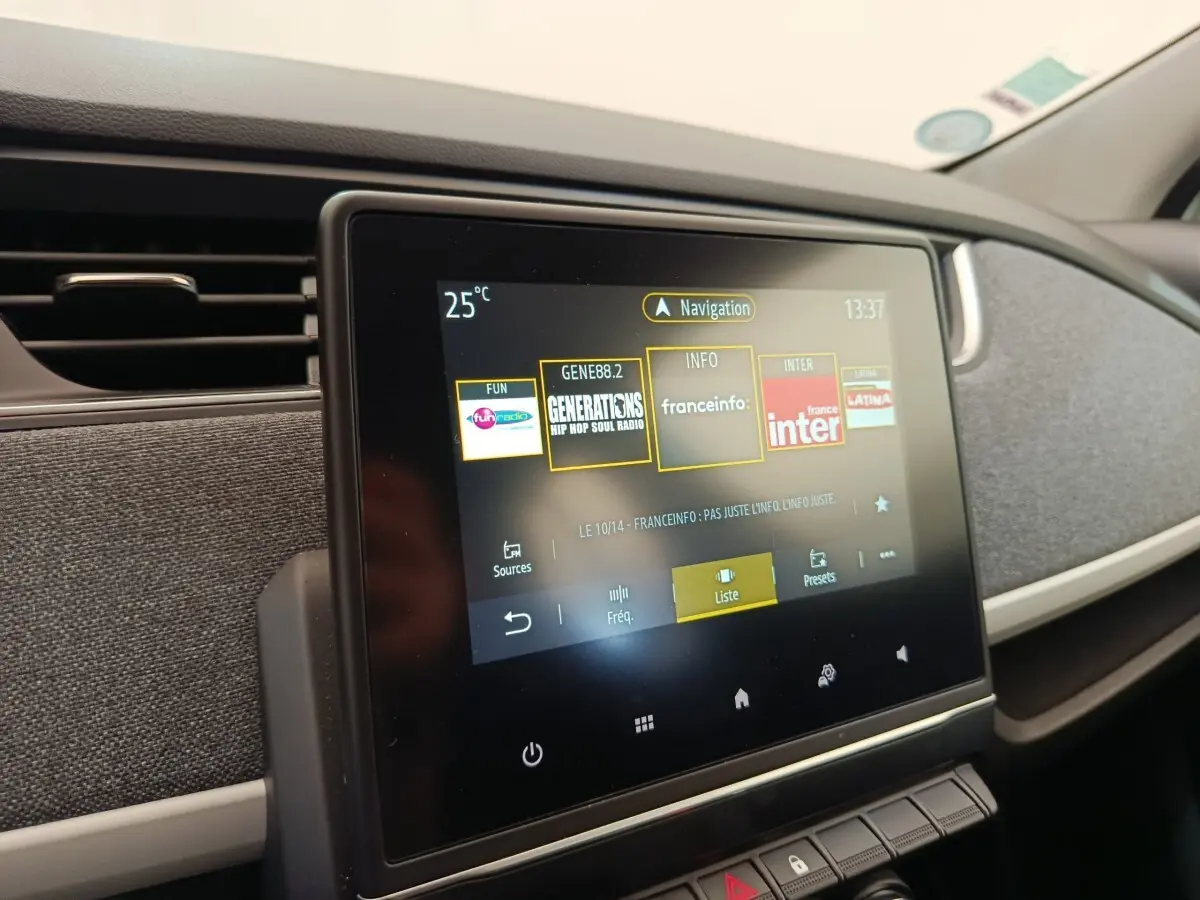 Écran tactile central du tableau de bord de la Renault ZOE blanche, affichant les stations radio.