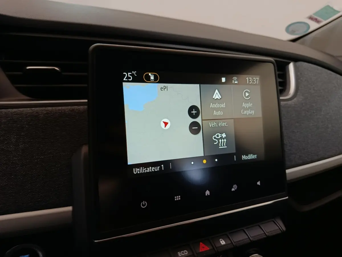 Écran tactile central du tableau de bord de la Renault ZOE blanche, affichant navigation et options connectées.