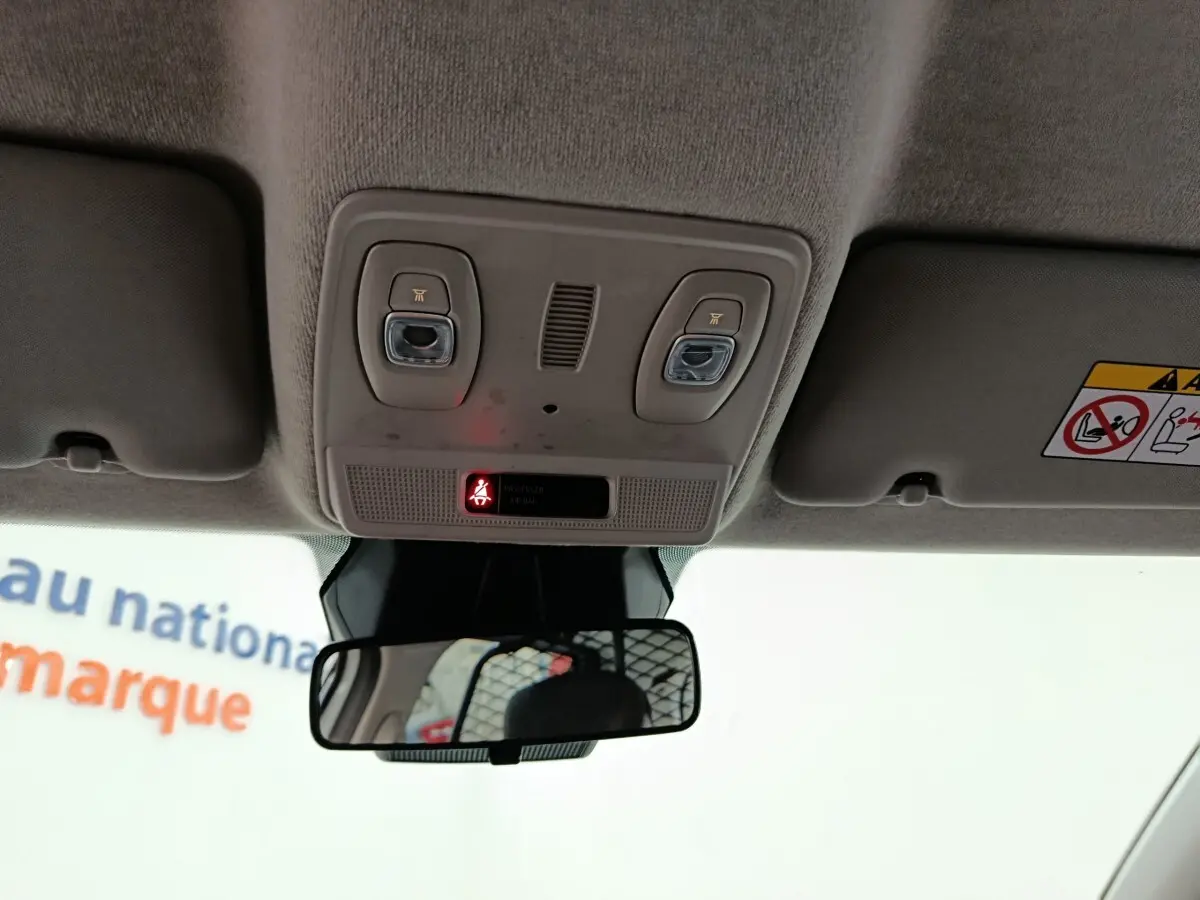 Vue intérieure du plafonnier et du rétroviseur central de la Renault ZOE blanche, version 2023.