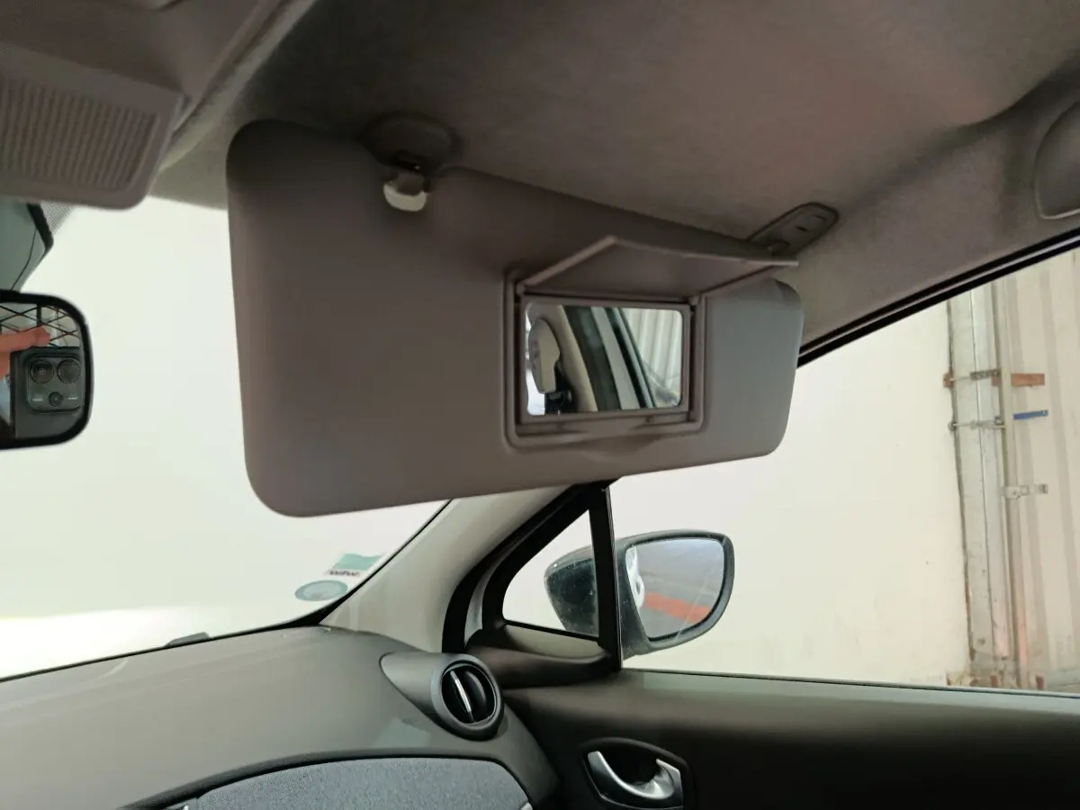 Intérieur de Renault ZOE blanc 2023, vue côté conducteur sur pare-soleil avec miroir de courtoisie ouvert.