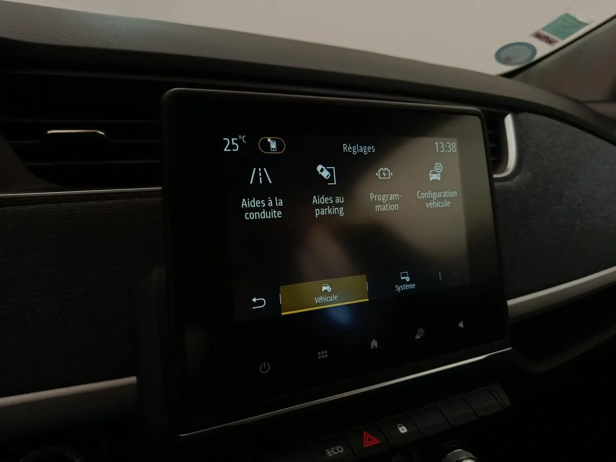 Écran tactile central affichant les réglages d’aides à la conduite dans l’habitacle d’une Renault ZOE blanche.