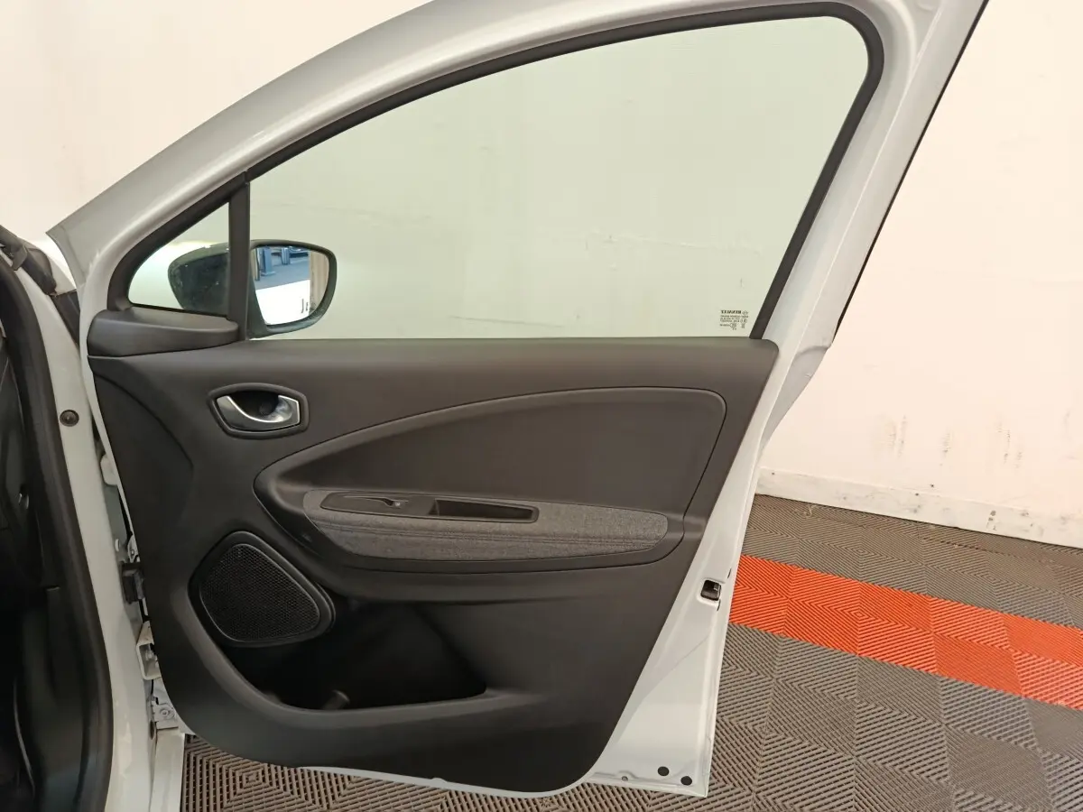 Vue intérieure de la porte arrière droite blanche d'une Renault ZOE 2023 avec garniture noire et grise.