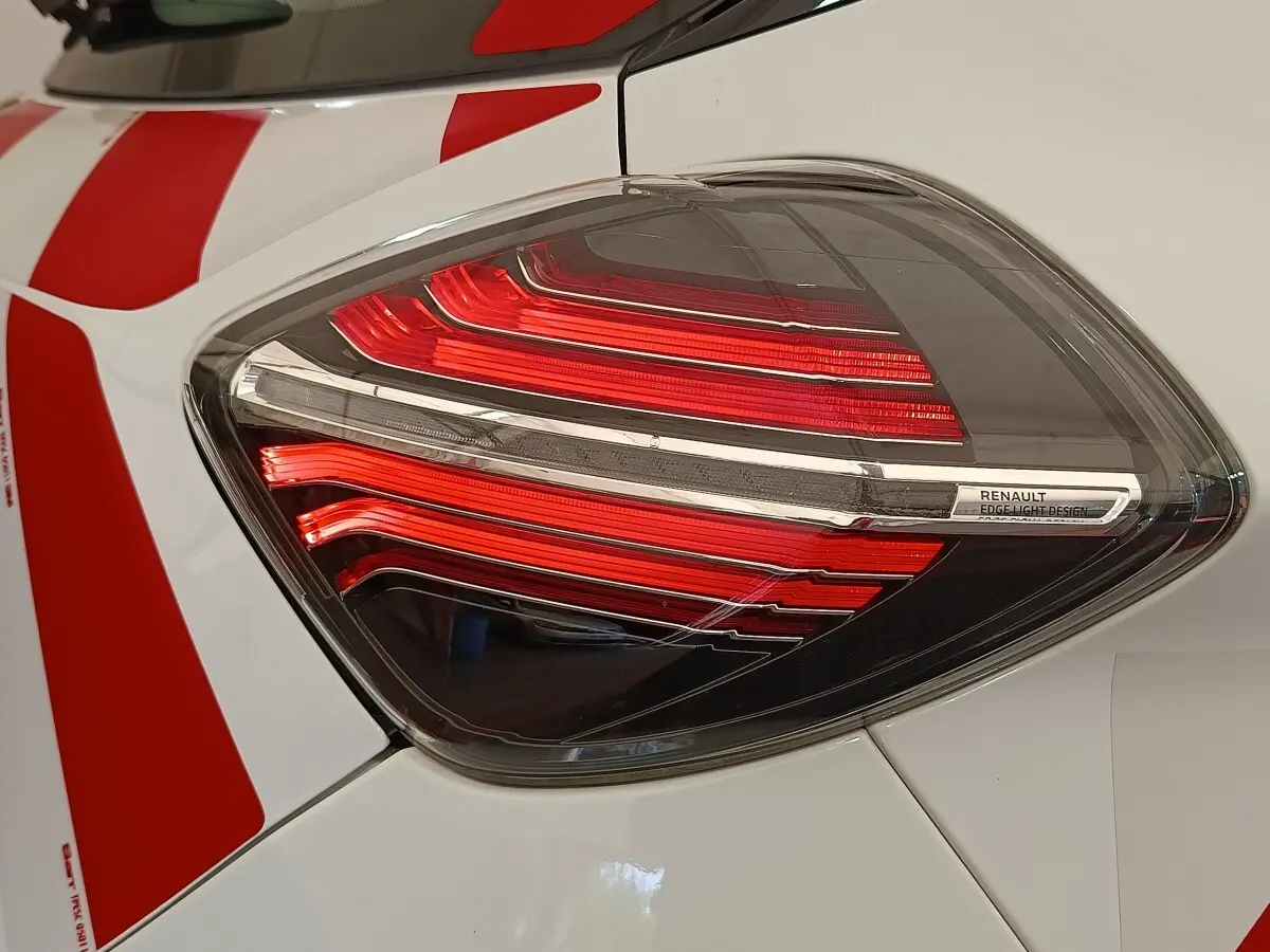 Gros plan sur le feu arrière droit rouge et blanc d'une Renault ZOE blanche avec bandes rouges.